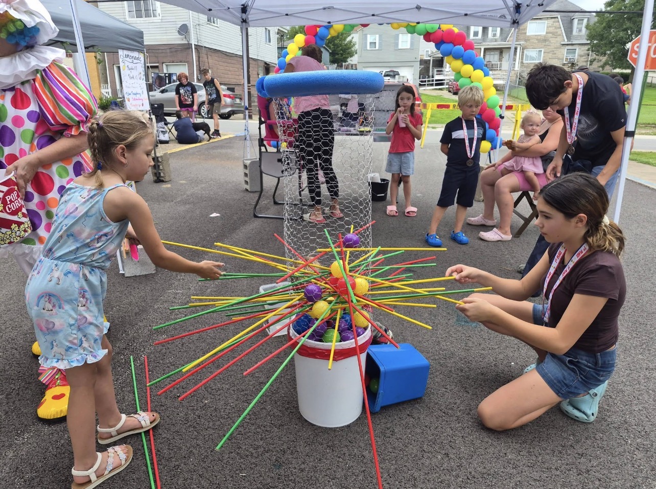 Children playing a colorful game at the Rose Garden Community Barbecue in June 2026