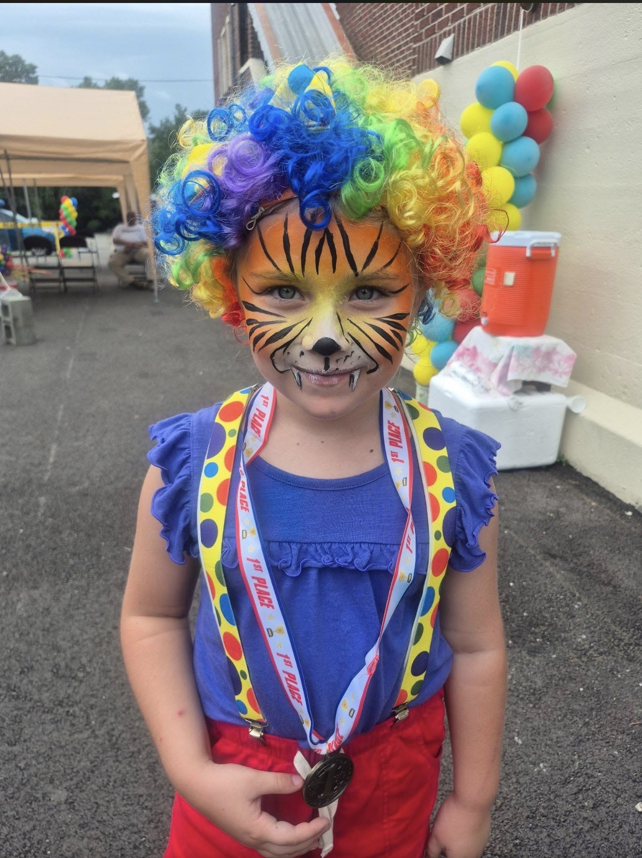 A young participant in colorful face paint at the Rose Garden Community Barbecue in June 2026